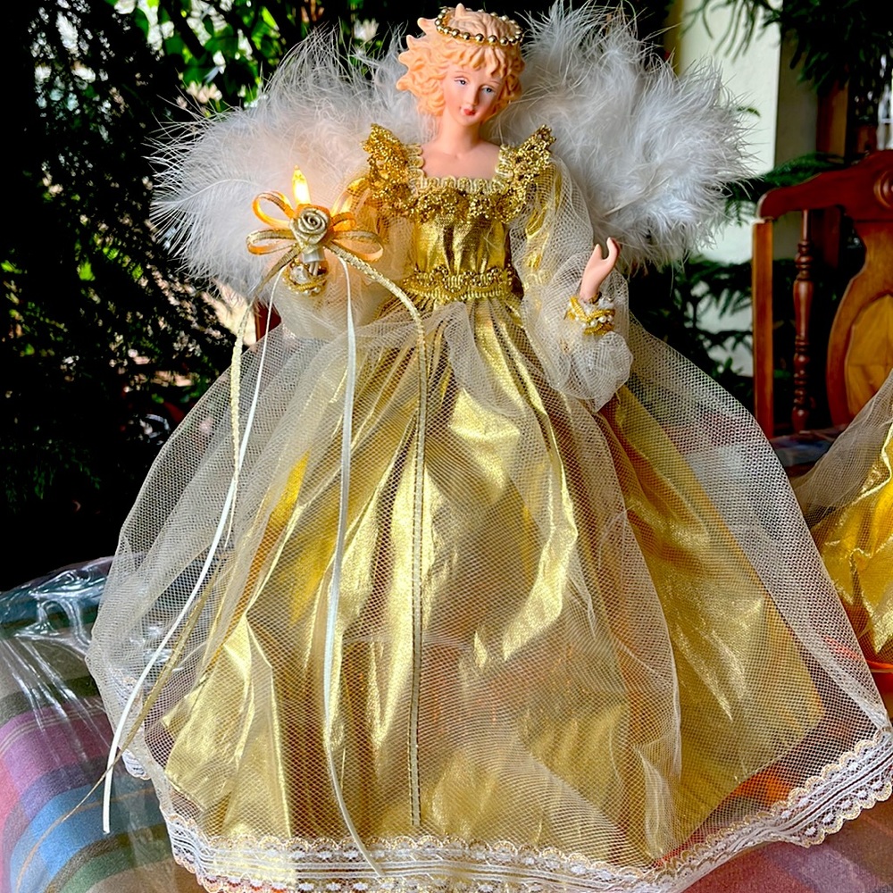 Tree or tabletop 14” plug-in lighted angel dressed in a gold holds a mini light.